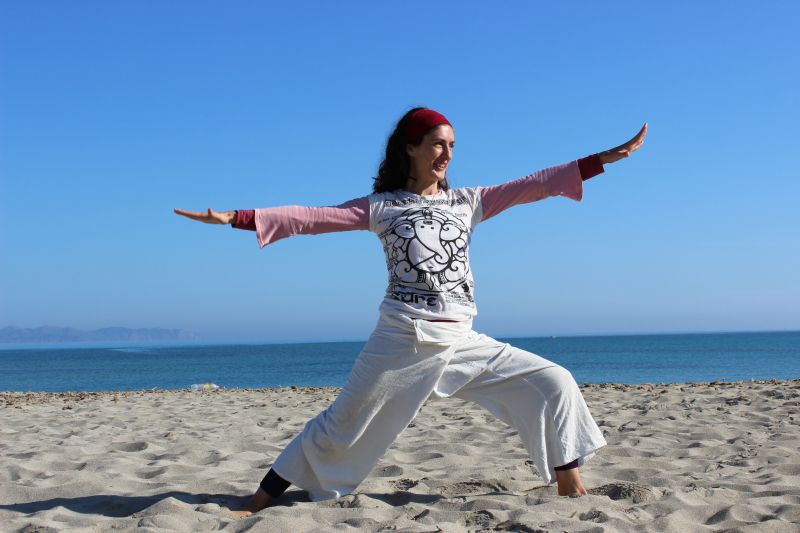 Frau macht Yoga am Strand